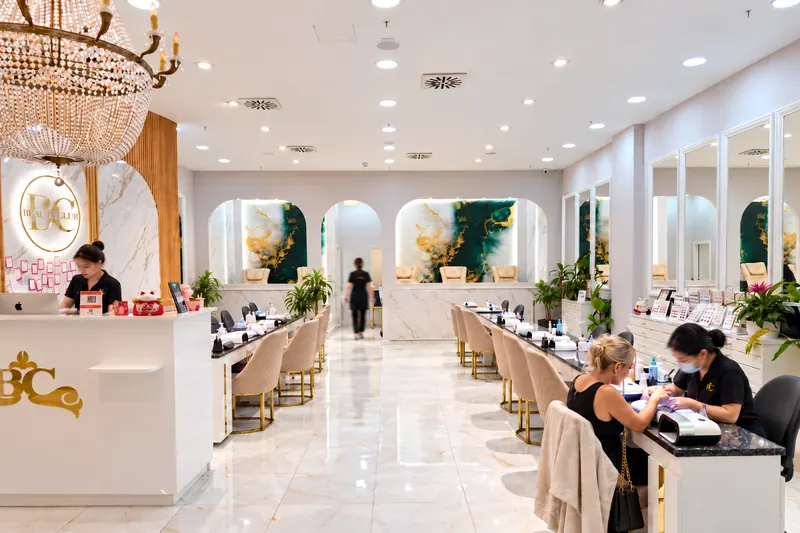 Blick in den Salon mit Empfang, BC-Logo und Maniküre-Plätzen vor hellen Bögen