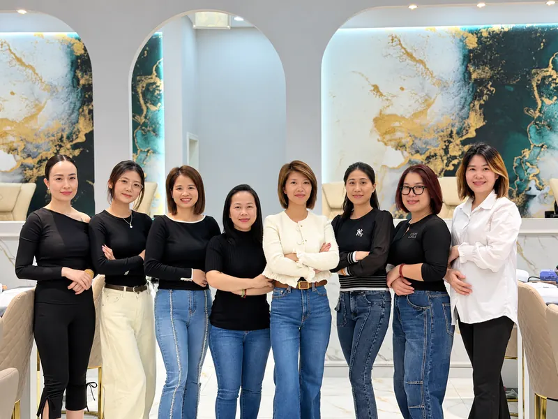 Die Mitarbeiterinnen von Beauty Club Minto vor der grünen Marmorwand